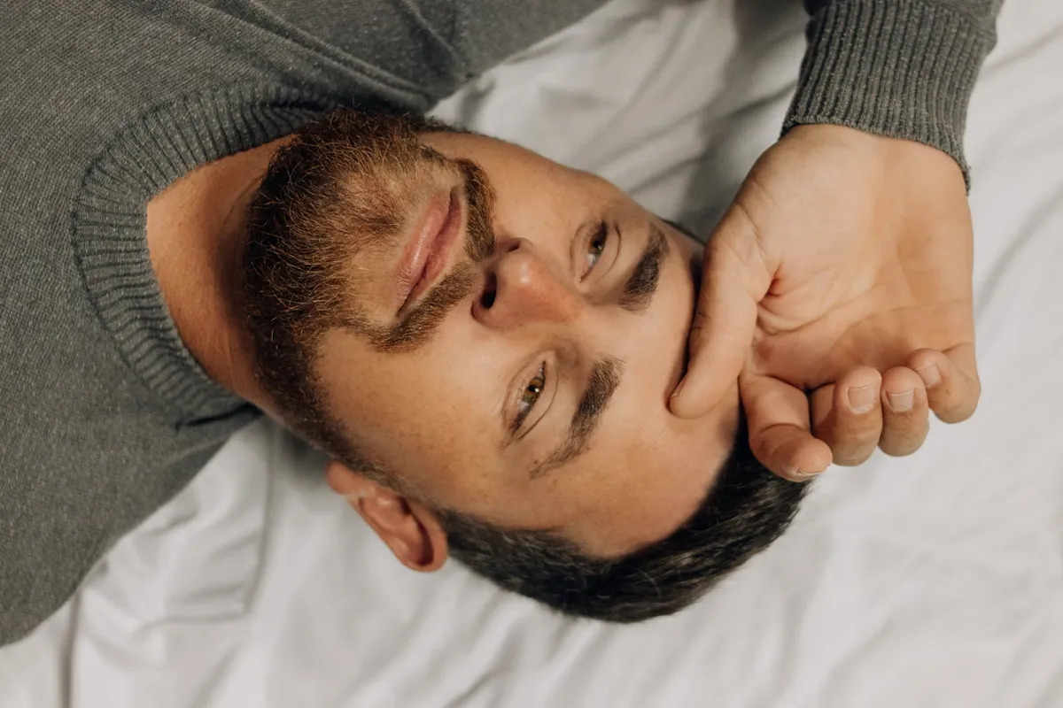 איש מתוסכל שוכב על מיטה