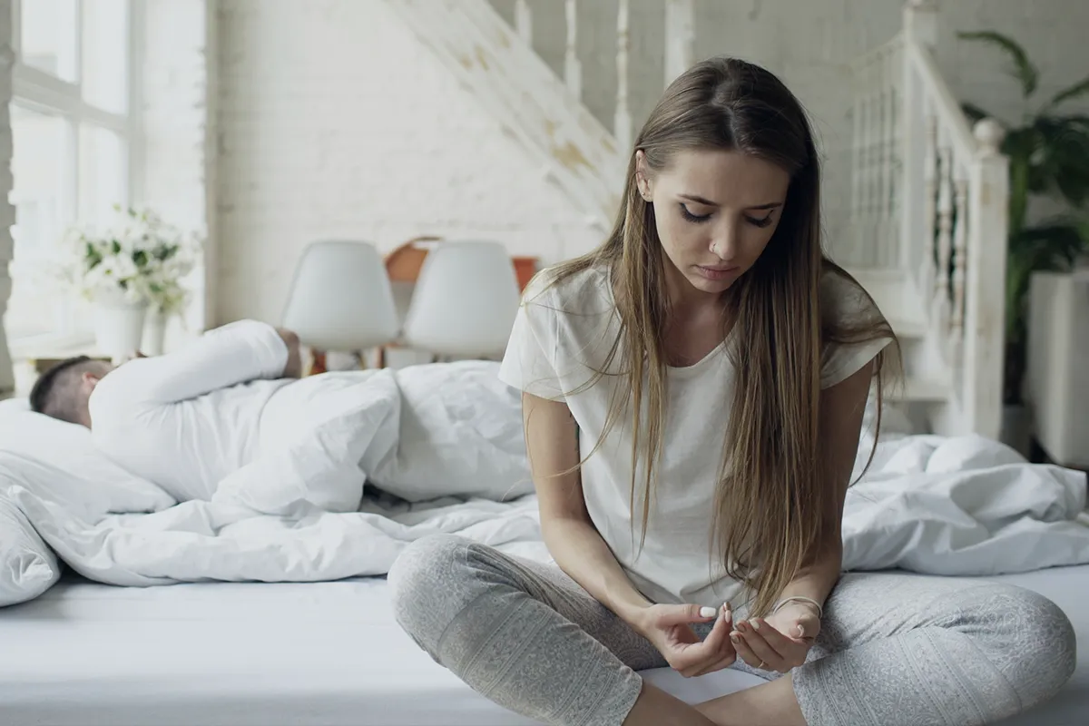 אישה מרוחקת במיטה